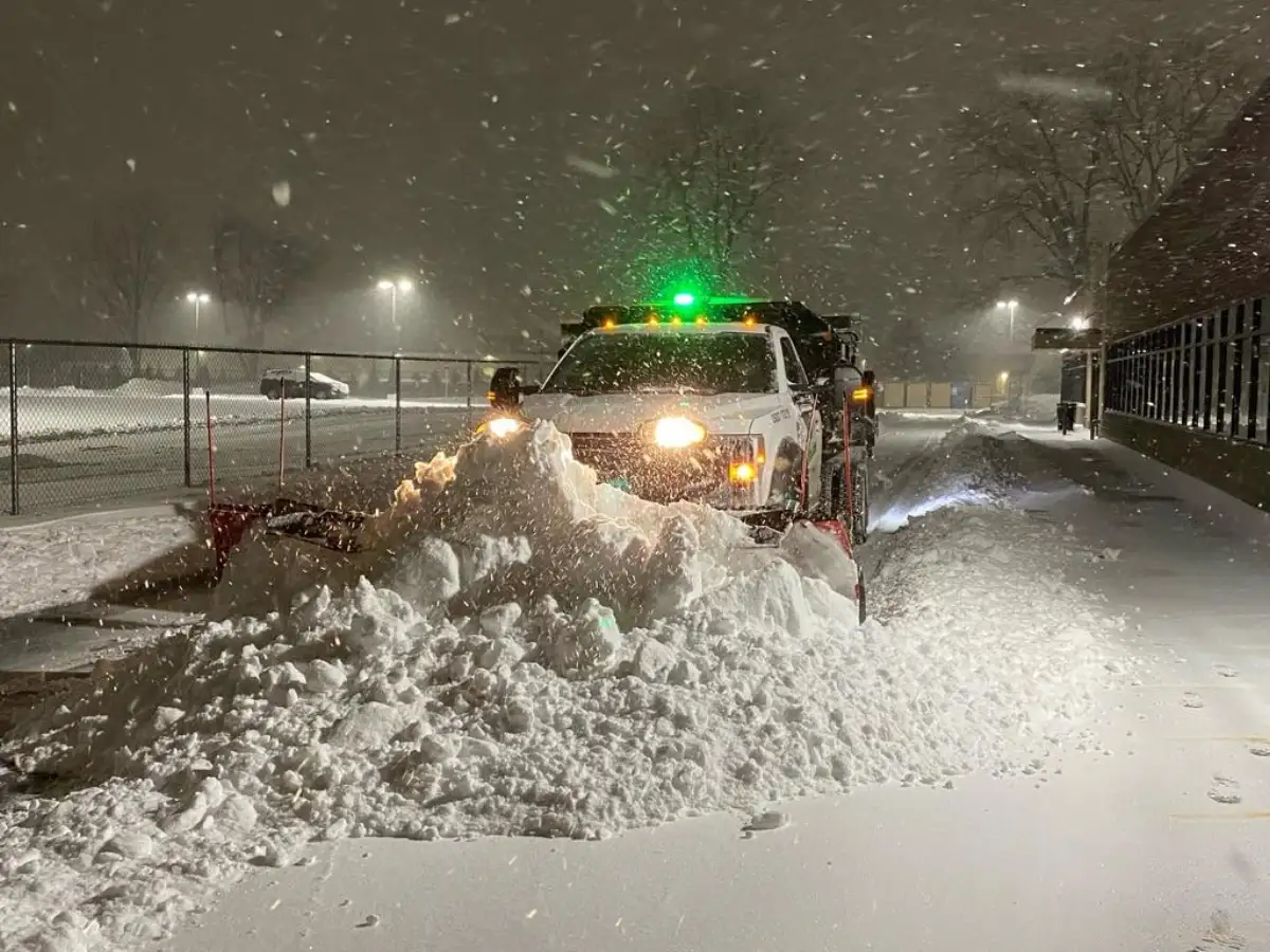 Heavy snowfall plowing operations at night in Metro Detroit