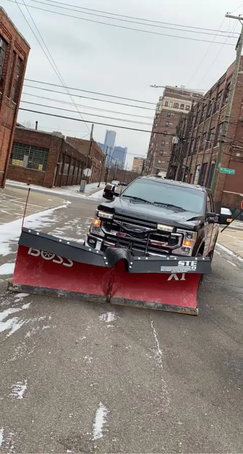 Snow plow clearing urban street during winter storm