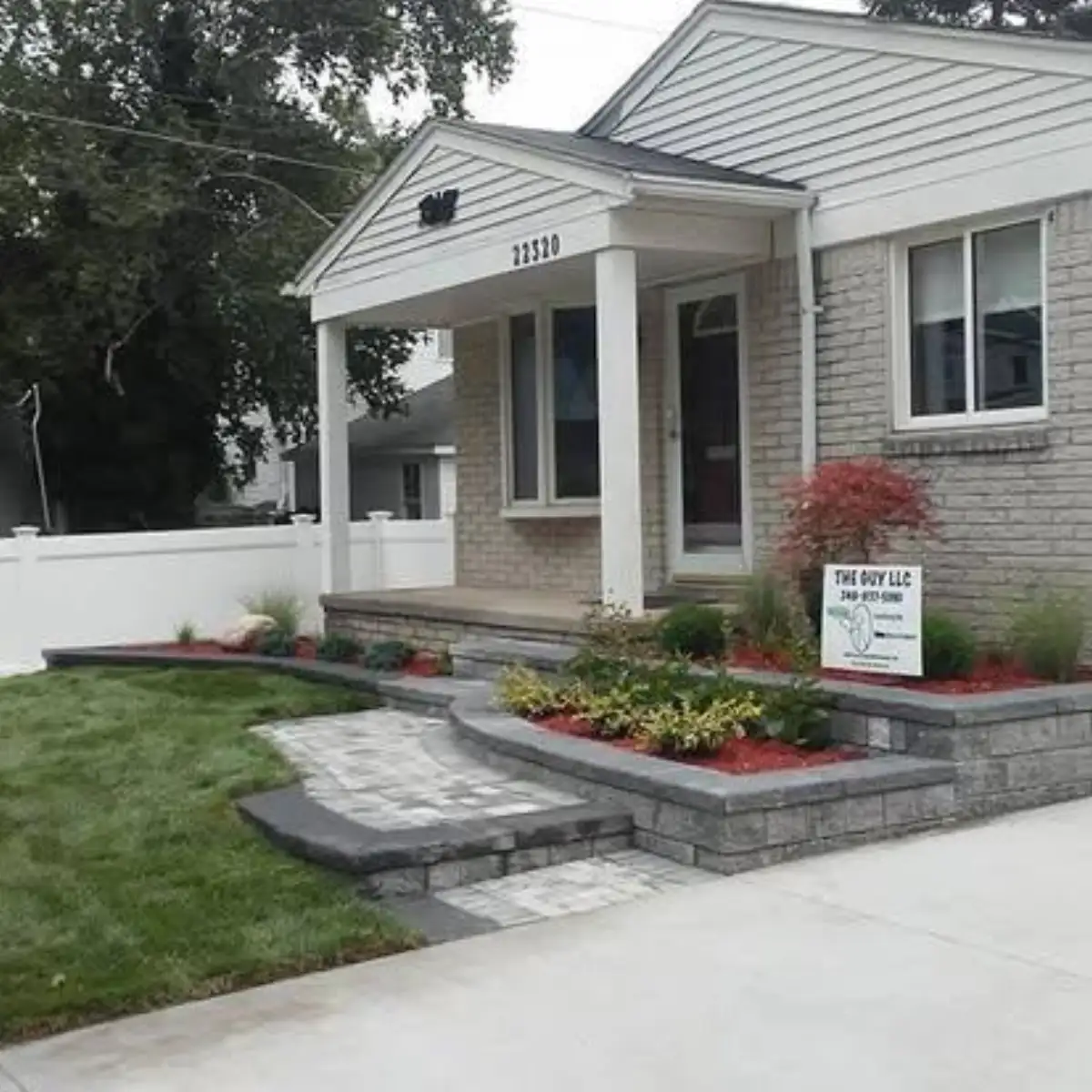 Full front yard transformation with tiered walls, walkway, and Japanese maple