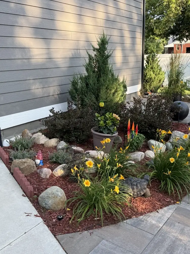Colorful garden corner with daylilies, junipers, and ornamental grasses