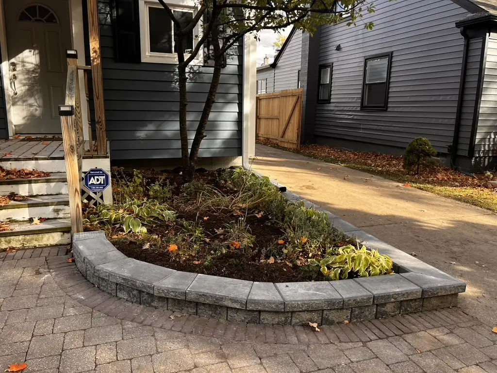 Completed segmental block retaining wall with landscape plantings by The Guy Outdoor Services