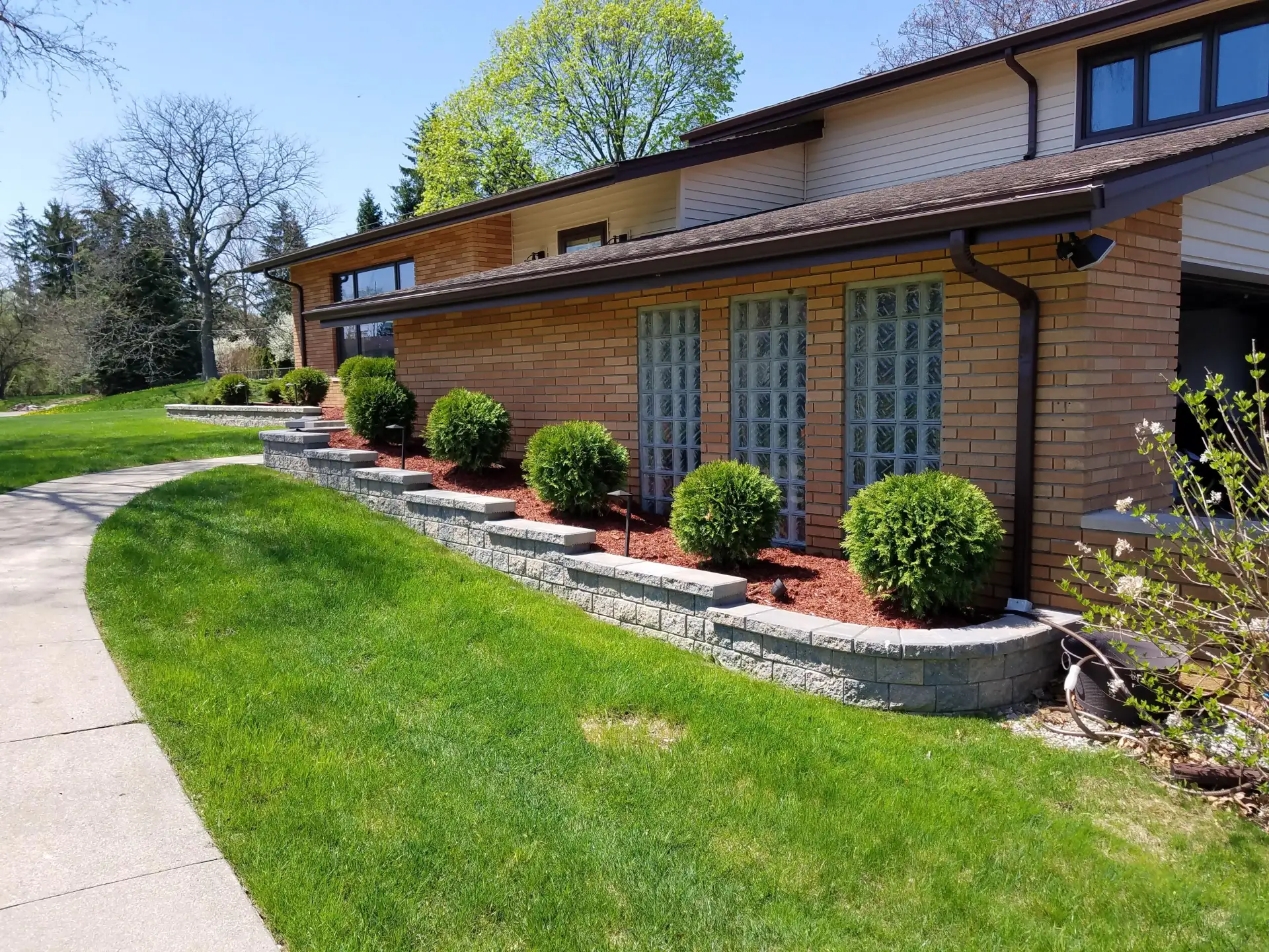 Natural stone retaining wall installation by The Guy Outdoor Services in Metro Detroit